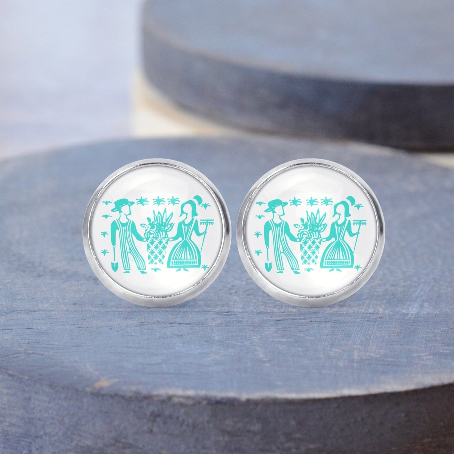 Butterprint Pyrex people printed on surgical steel stud earrings displayed on a gray wood background.