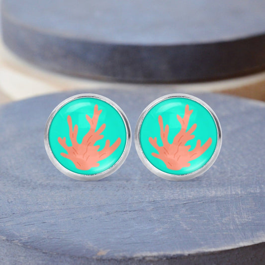 coral reef pink and turquoise background surgical steel stud earrings displayed on a wood background