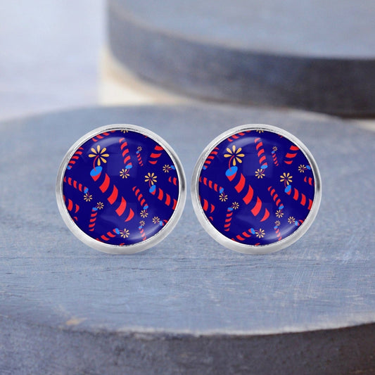 14mm fireworks design printed on silver nickel free post earrings. Blue background with red and blue fireworks. 